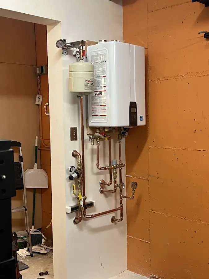 Plumbing technician inspecting water heater connections in Mountain Green